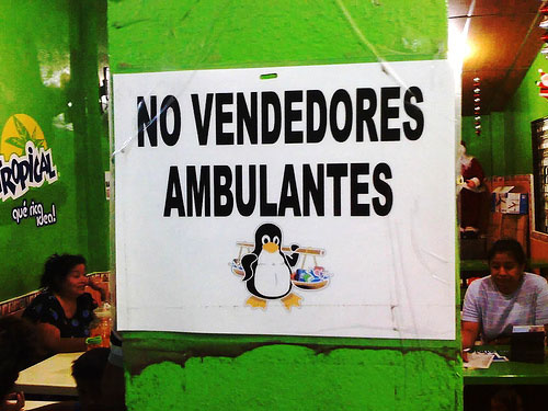 Tux pluriempleado vendiendo baratijas